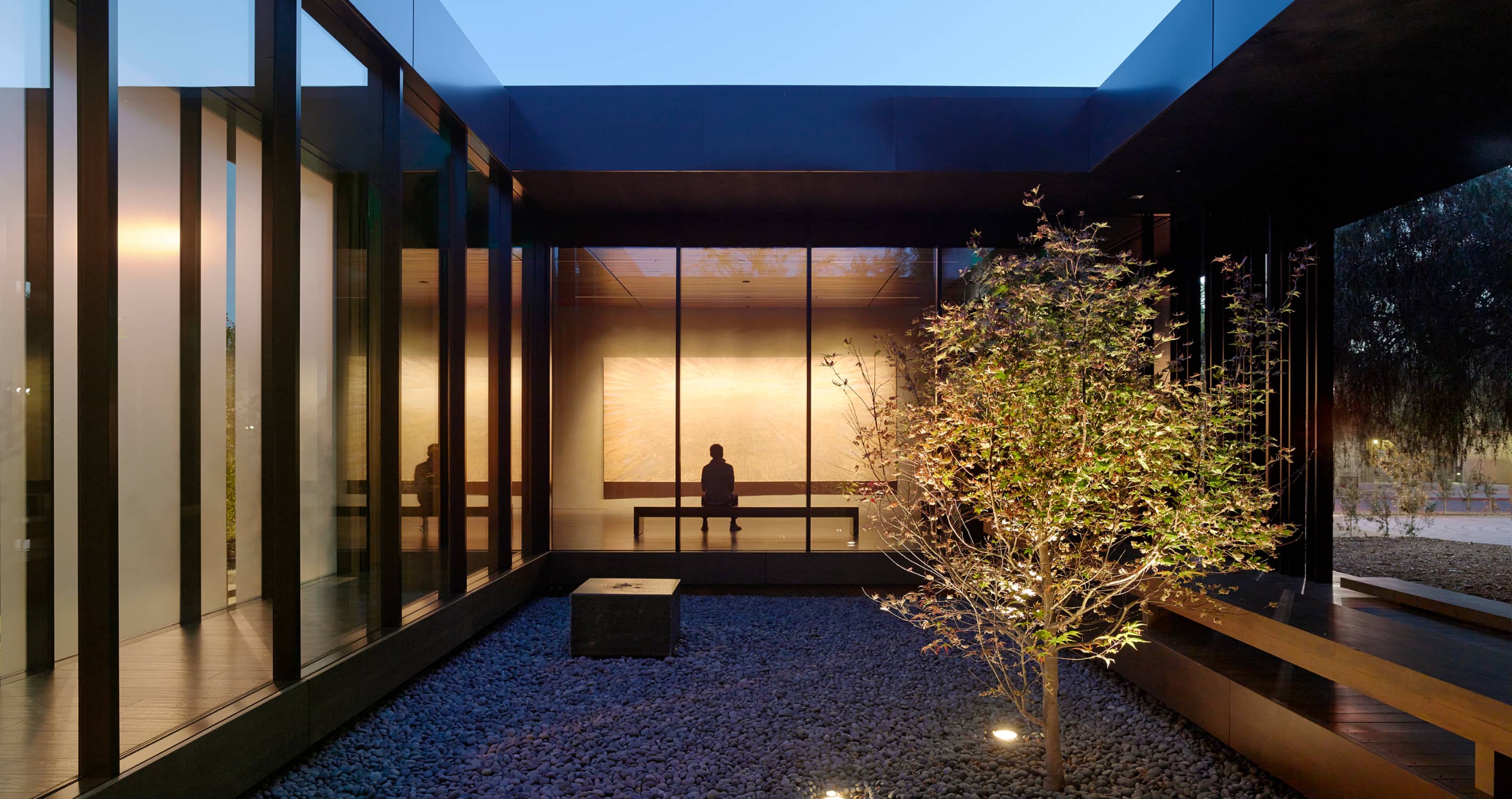 At night, the transparency of the building is most evident from the exterior, with artwork and landscape combining to create a meditative view. Stanford University - Windhover Contemplative Center, Palo Alto, California. © Matthew Millman