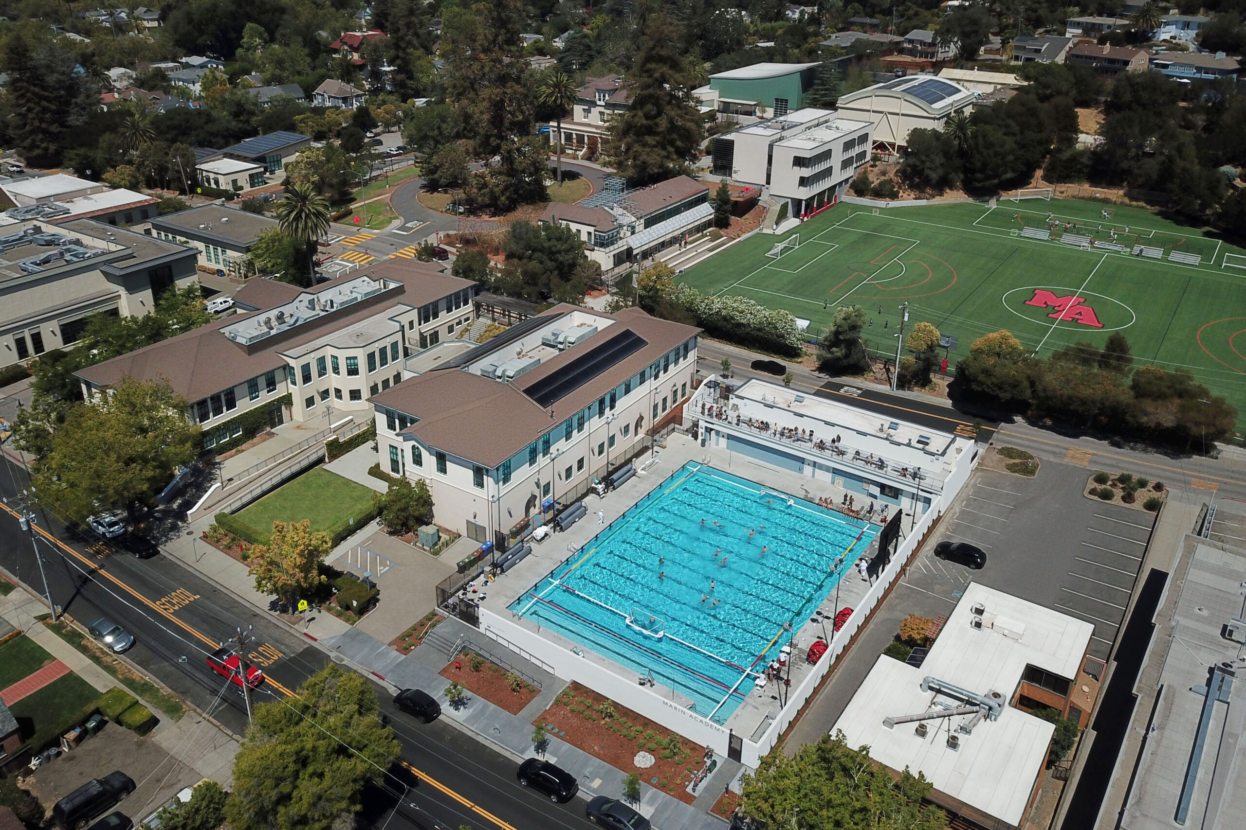 The Aquatic Center is tightly sandwiched between existing buildings with lighted areas of activity close to site boundaries. Marin Academy Aquatics Center, San Rafael, California © Daniel Peak