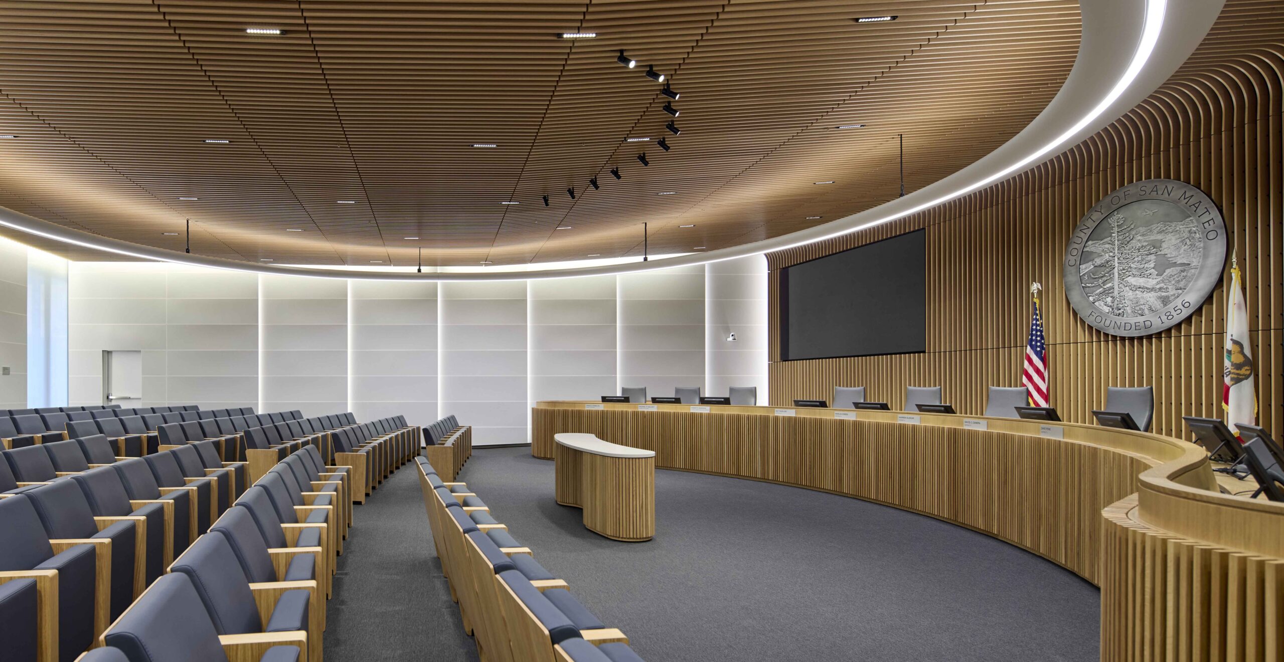 Board of Supervisors Chambers at San Mateo County Headquarters featuring circular seating, daylight-filled design, and net-zero civic architecture by SOM and Apeiro Design.