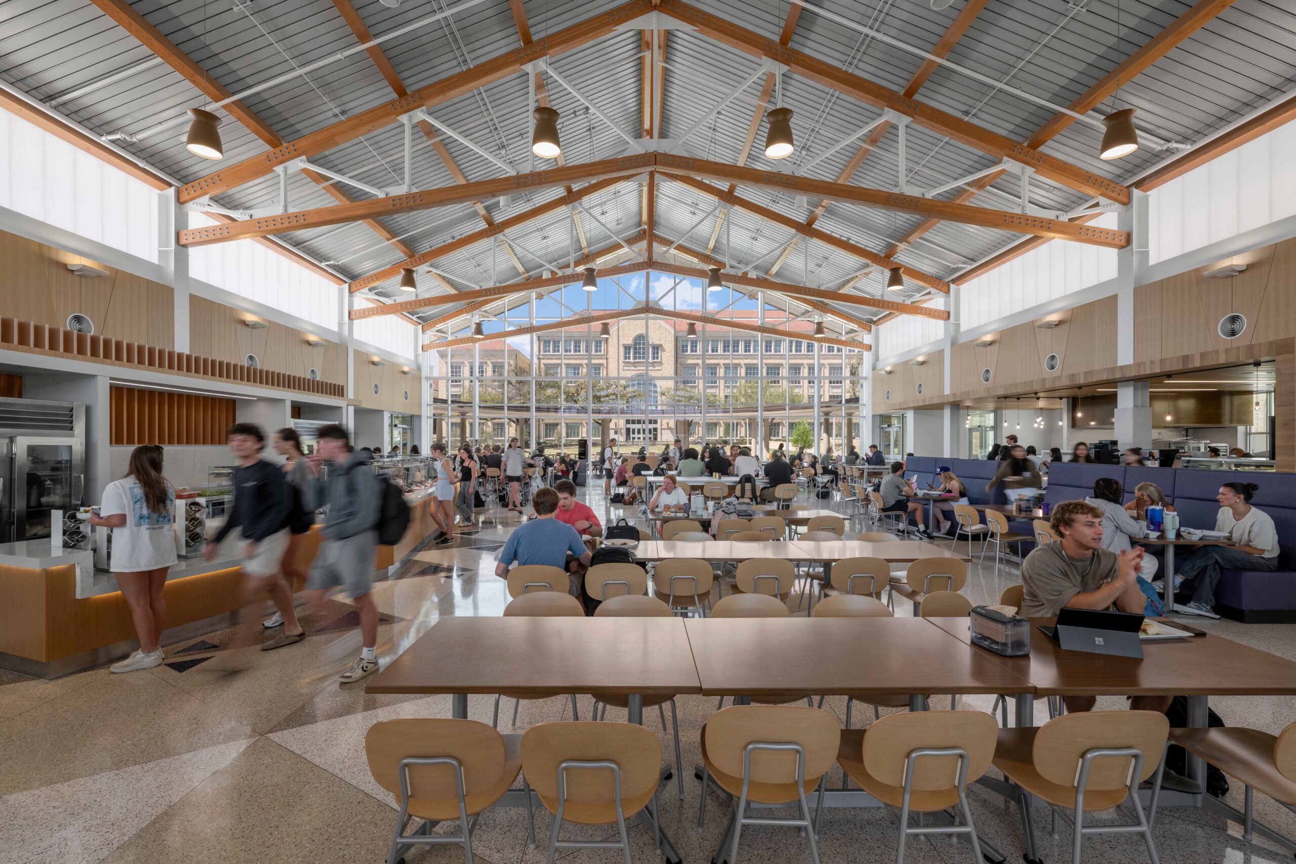 Oriented with almost true west and east double-height glazed facades, the building’s access to daylight as the primary light source for most of the operating hours creates a lively and cheerful interior. Electric lighting delivers higher intensities at the middle portion of the space to infill the tapering daylight volume and maintain the sense of brightness across the dining area. The two-story dining hall is daylit by clerestory windows and glows like a lantern by night, serving as the social and visual anchor of TCU’s new student neighborhood.