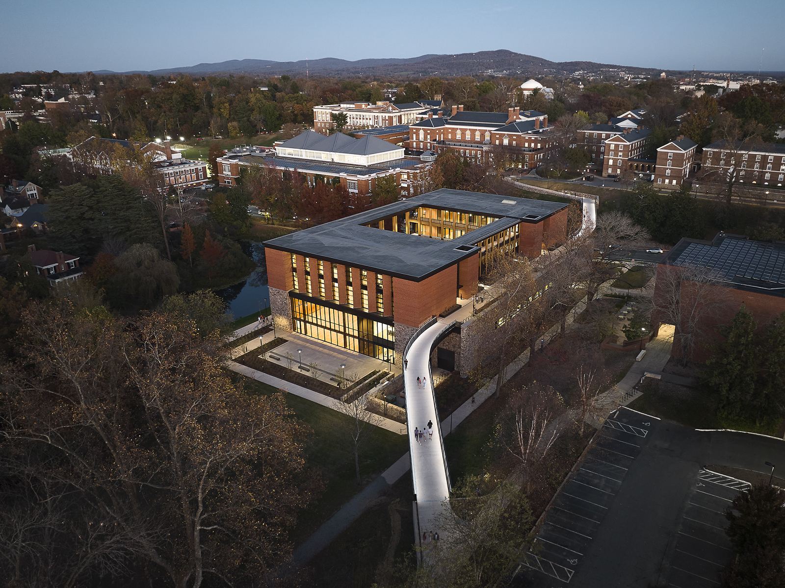 Contemplative Commons at twilight with soft site lighting extending warmth into the surrounding landscape.